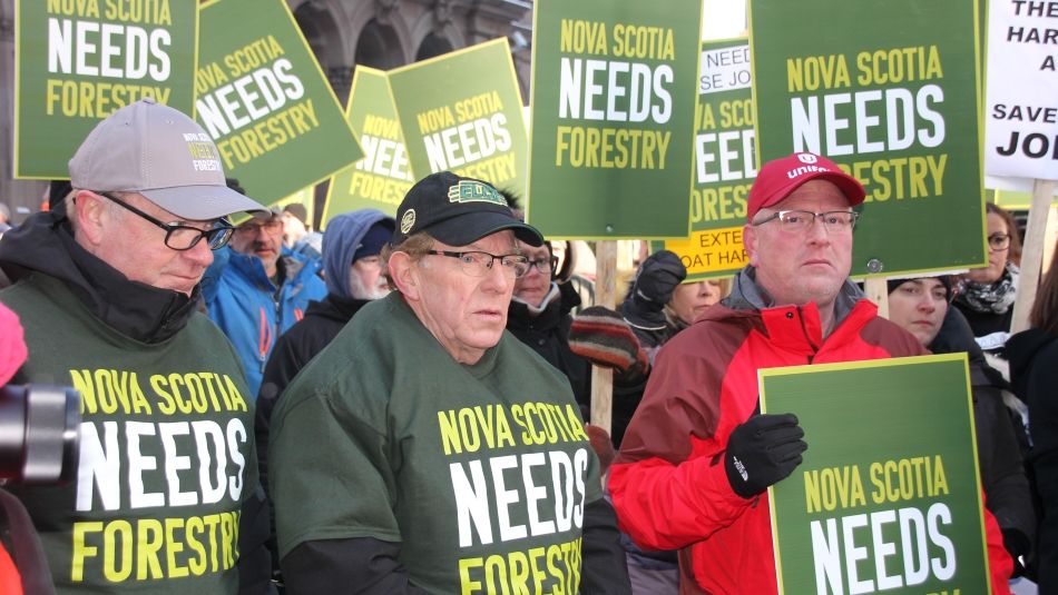 Nova Scotian forestry industry advocates hold signs reading "Novs Scotia Needs Forestry."