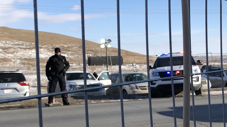 A police officer stands next to his vehicle at a picket line.