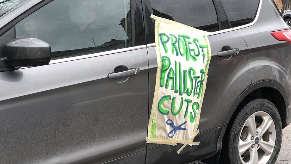 A sign taped to a car reads: "Protest Pallister Cuts."