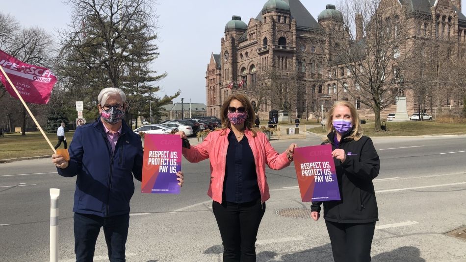 Fred Hahn President CUPE Ontario, Katha Fortier, Assistant to the National President, Unifor, Sharleen Stewart, President, SEIU Healthcare holding signage 'Respect us. Protect us. Pay us.'