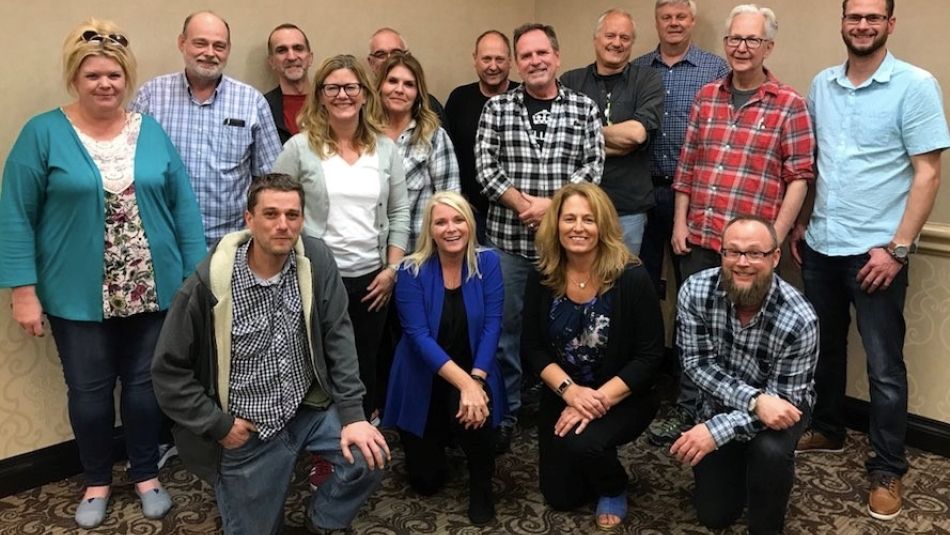 A group of workers smile at the camera.