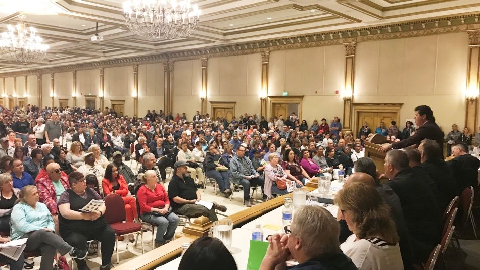 Jerry Dias est debout sur un podium et s'adresse à une salle remplie de membres d'Unifor.