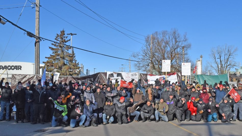 Des members de la section locale 728 d'Unifor devant l'usine de Paccar à Sainte-Thérèse, Qc.