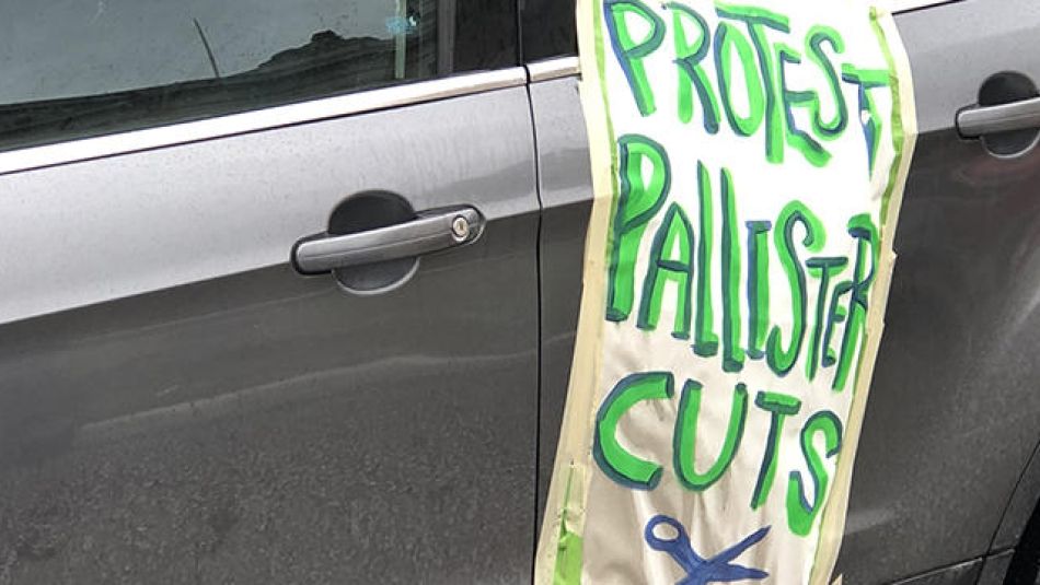 A sign taped to a car reads: "Protest Pallister Cuts."