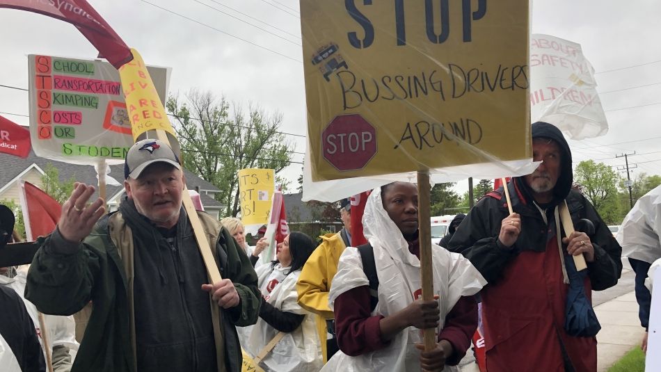 Members of Unifor local 4268 hold protest signs.