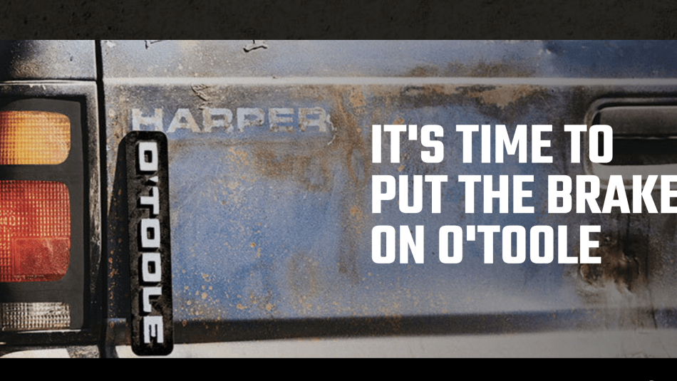 back of an old pickup truck decaled with Harper and O'toole text reads: It's time to put the breakes on O'toole