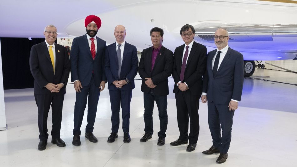 Jerry Dias, Vic Fideli, Navdeep Bains, Alain Bellemare, Howard Eng, and Paul Sislani pose in front of an aircraft.