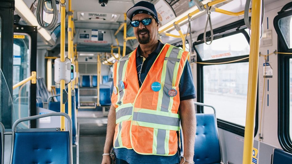 A transit worker stands on an emty bus.