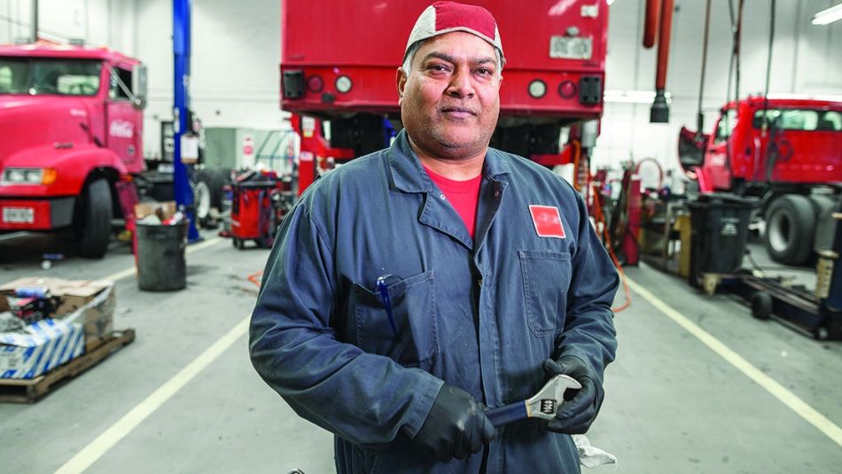 Worker in coveralls in a truck shop