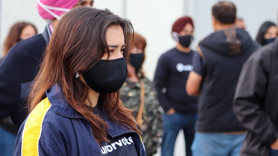 A Unifor member in a mask, and a “Unifor Votes” t-shirt at a recent provincial election event.