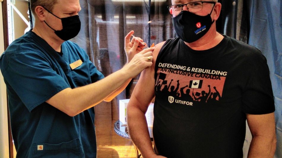Unifor National Rep Tom McNamara receives COVID-19 vaccine injection in Nova Scotia by a nurse.
