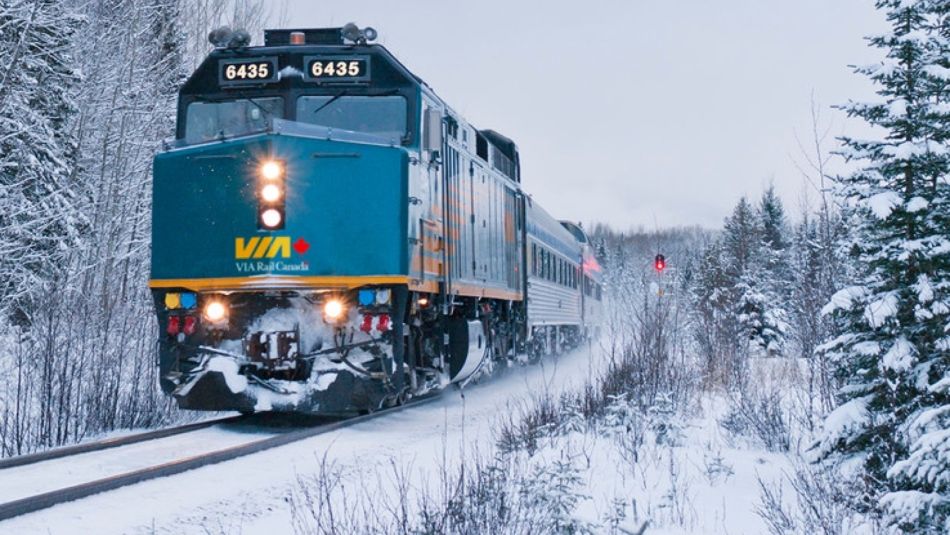 Locomotive VIA Rail en déplacement lors d’une journée d’hiver enneigée.
