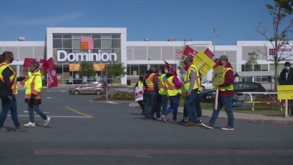 Members of Unifor Local 597 on a picket line outside a Dominion store.