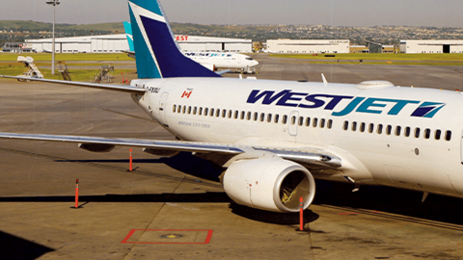 A West Jet plane at an airport gate.