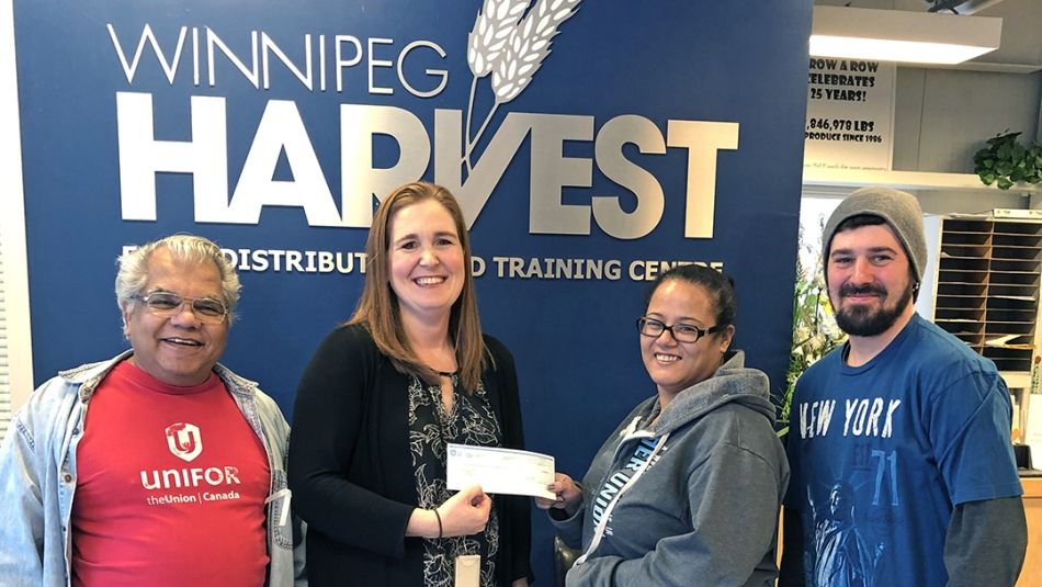Des membres d'Unifor présentent un cheque à Winnipeg Harvest Food Distribution.