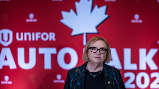Lana Payne in front of a red and white backdrop "AutoTalks 2026" Unifor logo