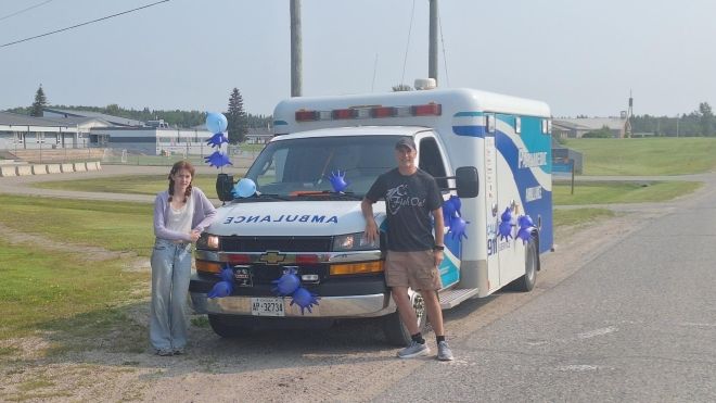 An ambulance and two kids standing on either side
