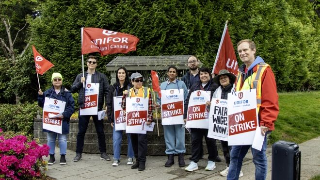 Local 3000 members on the picket line pose beside Arbutus Club signage