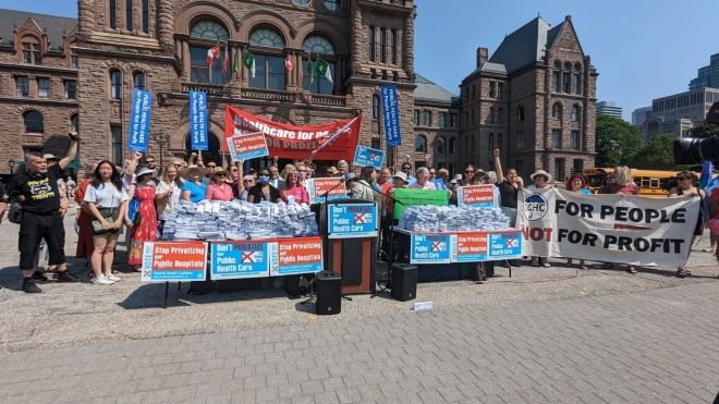 A health care rally group in front of Queen's Park holding banners