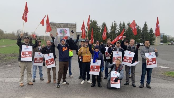a group of workers holding on strike signs 