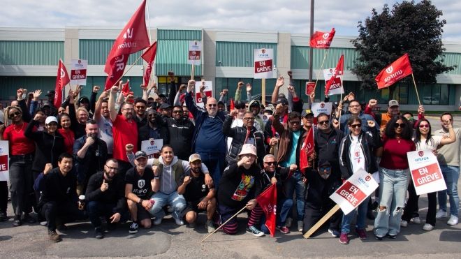 A large group of DHL workers with arms raised 