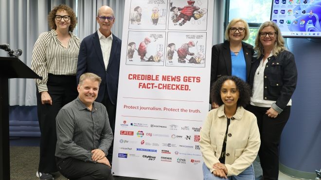 six people standing beside a x-stand banner.