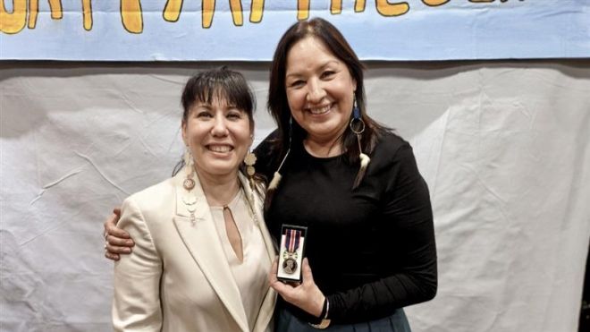 MP Leah Gazan posing with Gina Smoke holding her medal. 
