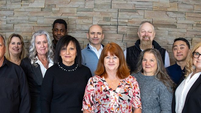 A group of people standing in front of a brick wall.
