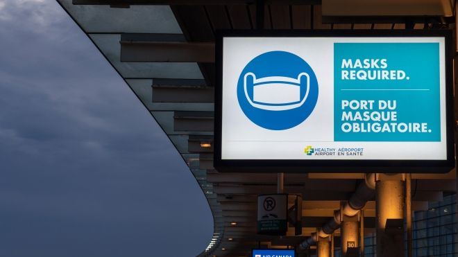 Mask requirement sign lit up in an airport