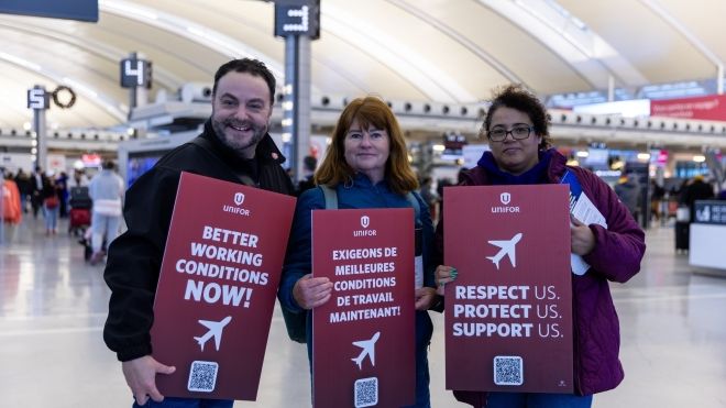 three people holding signs in the airport