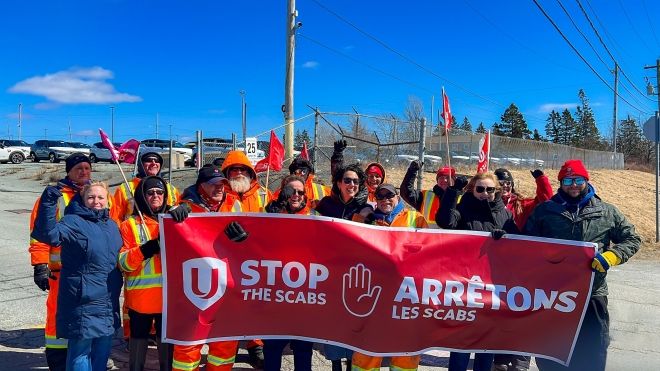 A group of people holding a 'Stop the Scabs' banner