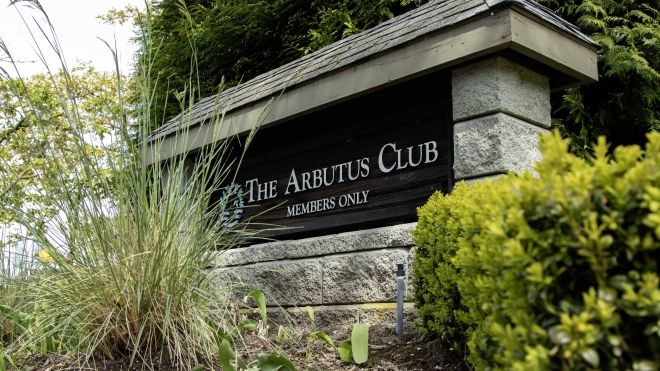 Arbutus Club stone signage surrounded by greenery