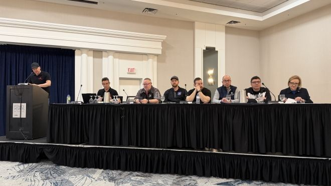 Eight people sitting behide a head table and podium.