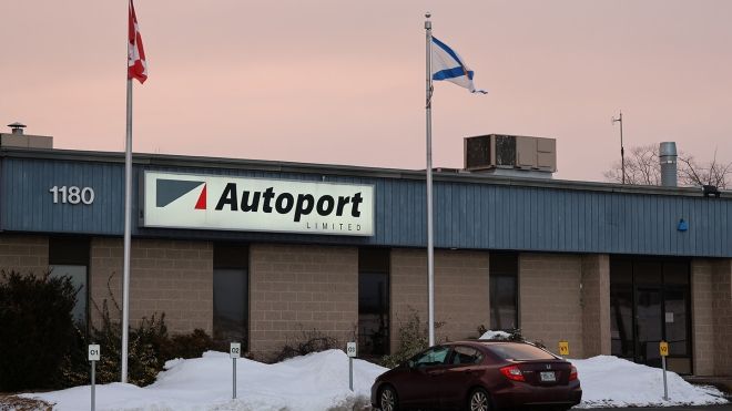 A car parked in front of a building with Autoport signage