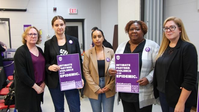 Cinq femmes posent avec des affiches de campagne.