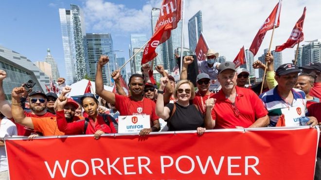 group of people marching with a worker power banner