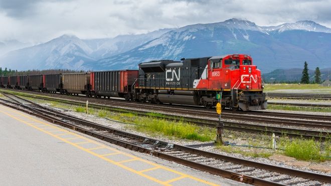 Canadian National CN Rail train engine transport pulling cargo through Canadian Rockies landscape in Jasper, Alberta, Canada.