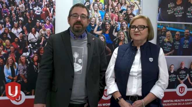 Lana Payne and Daniel Cloutier standing in front of wall banners