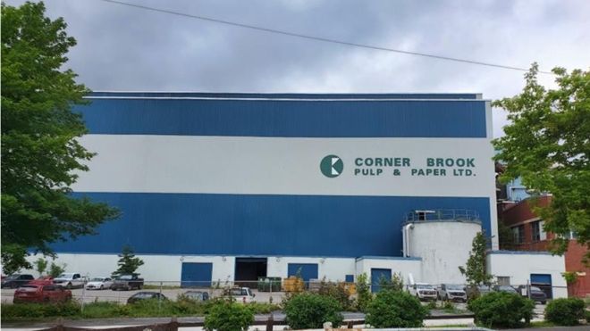 The exterior of a large industrial building with the Kreuger Paper logo on it.