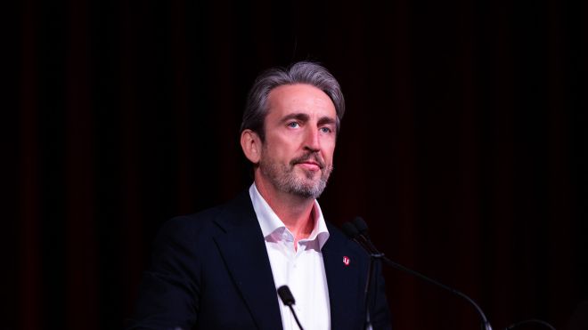 A man at a mic with a blackbackground