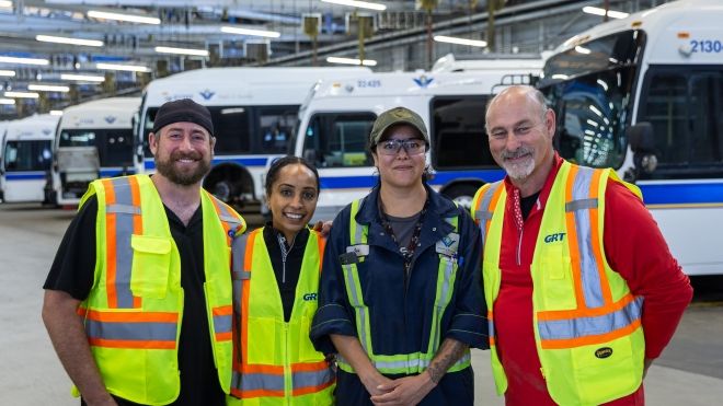 Unifor National Secretary Treasurer and Ontario Regional Director Samia Hashi pose for photo at bus depot with transportation workers. 