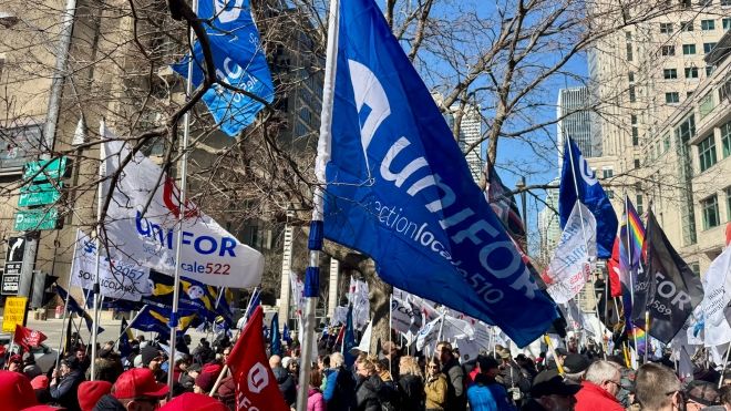 Unifor flags and a crowd of people marching