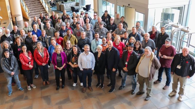 Large group of Alberta local leaders and Unifor national officers posing for photo from above in hotel lobby