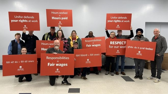 A group of people holding signs  that call for fair wages