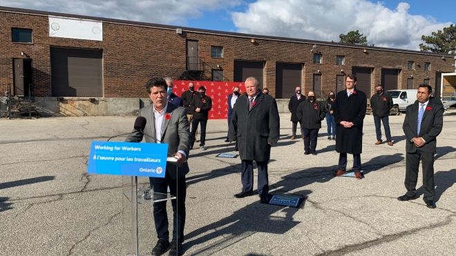 Jerry Dias stands at a podium outdoors at minimum wage announcement. 