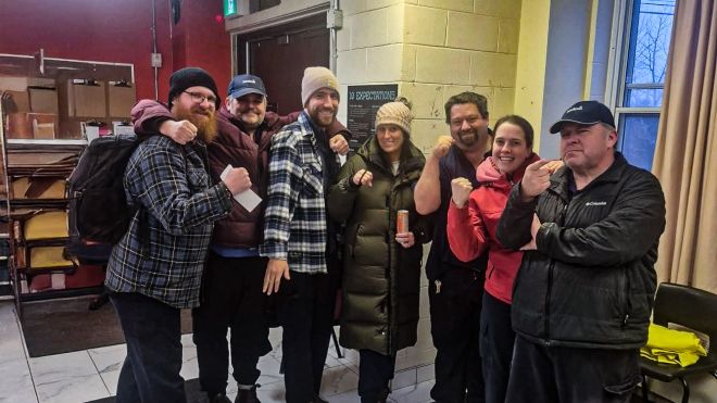 The Unifor Local 2107 bargaining committee members stand in a group giving thumbs up to the camera