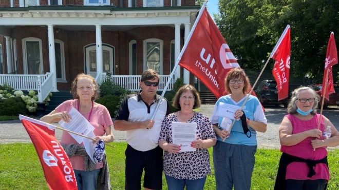 Shelter workers on the picket line holding flags