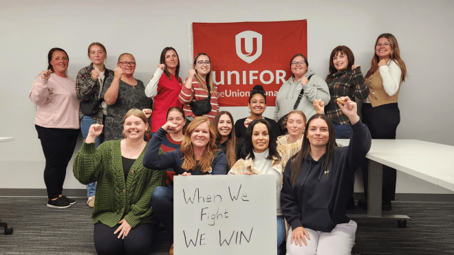 A group of women posing with a sign that reads, When we fight, we win!