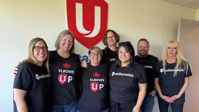 A group of seven people in Unifor Votes and Unifor Elbows Up t-shirts.