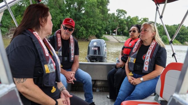 Poirier, Hashi, and Murray listening to Jill Wilson while sitting on a power boat).